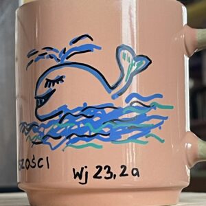 kubek z cytatem biblijnym i uśmiechniętym wielorybem